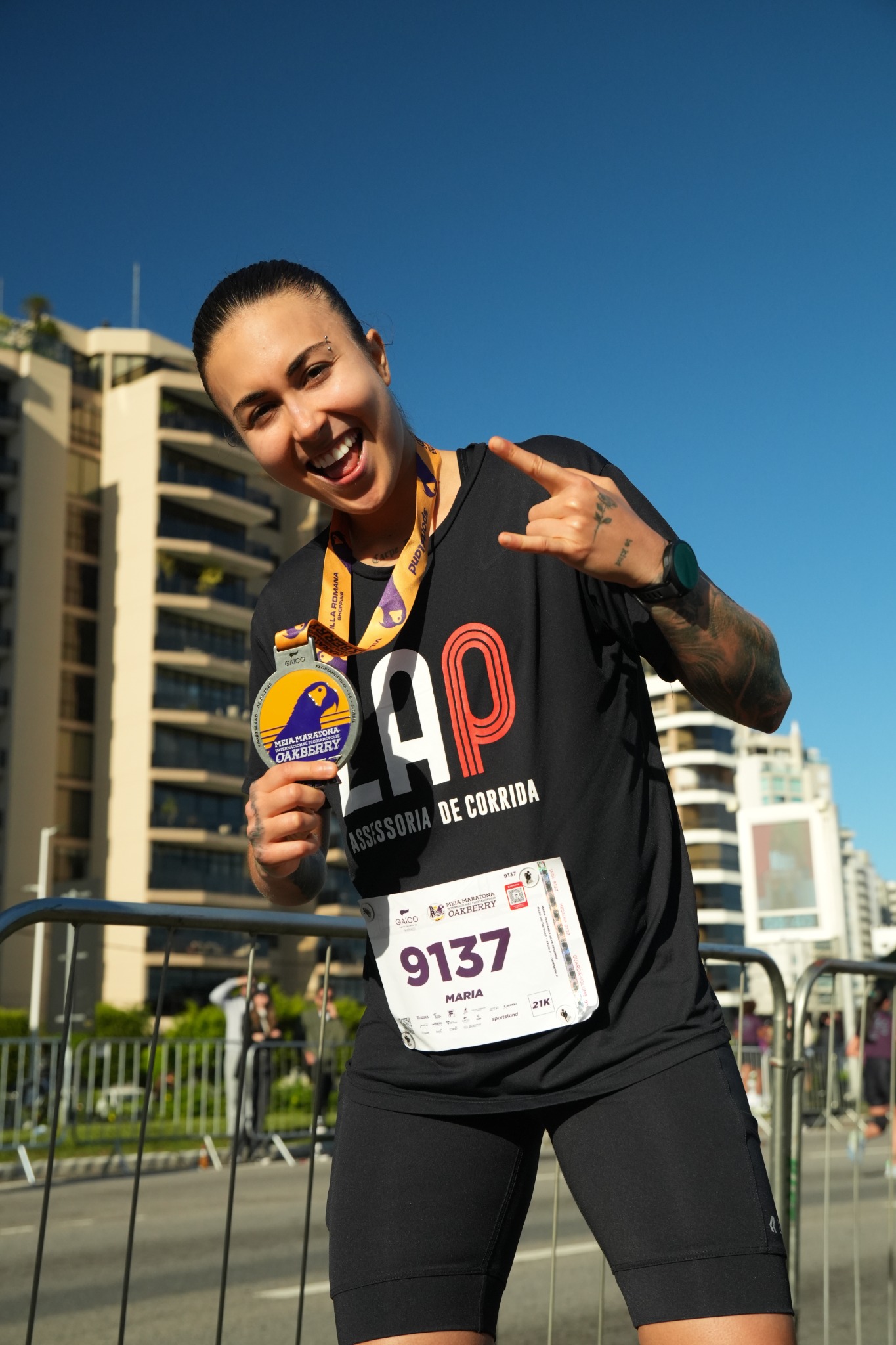 Mafê Resende sorrindo com sua medalha após uma prova de corrida